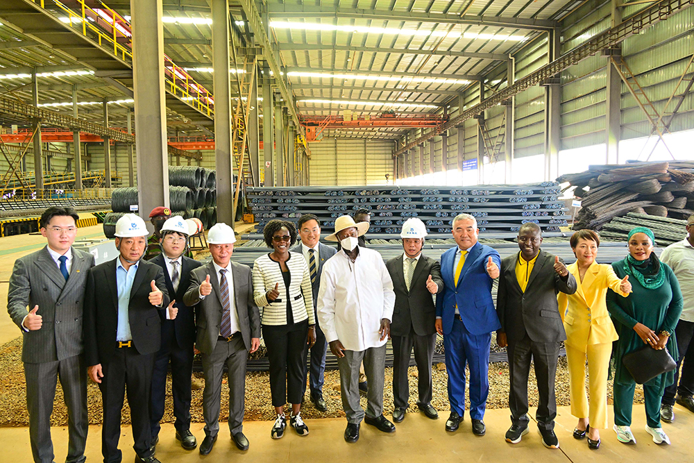 President Museveni (C) with Chinese investors and Ugandan ministers pose for a photo in front of some of the steel products made by Unisteel factory during its commissioning in Mbale on Friday. (PPU Photo)
