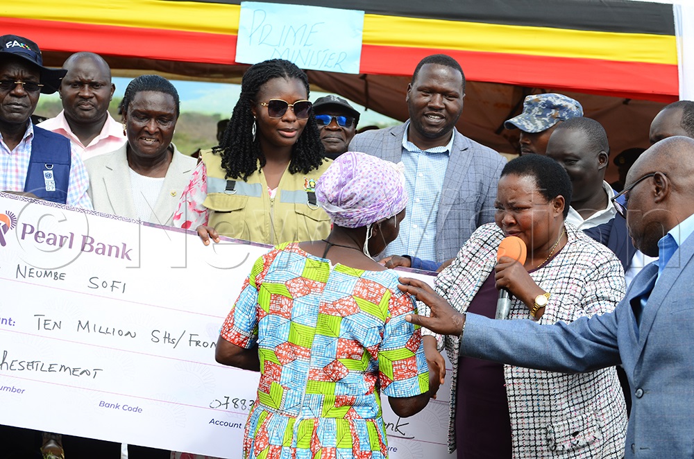 Prime Minister of Uganda, Robinah Nabbanja, hands over a package to one of the beneficiaries. (Credit: Paul Watala)