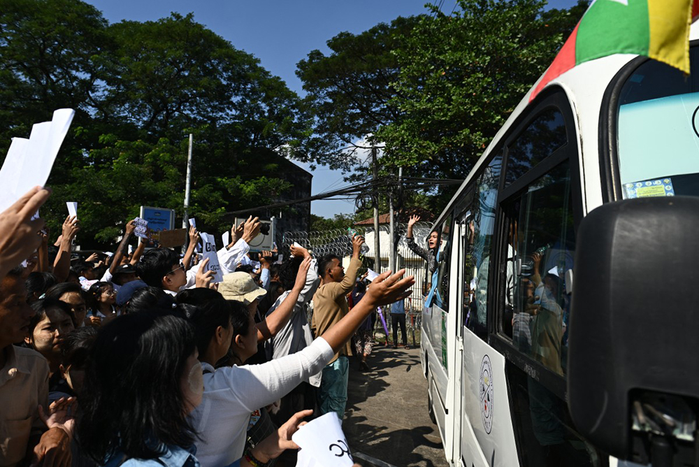Relatives gather around a bus carrying released prisoners out of Insein prison during an annual amnesty to mark Myanmar's independence day in Yangon on January 4, 2026. 