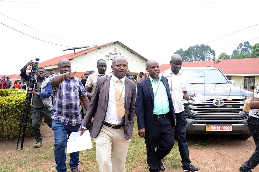 Simon Nabaasa (second from L), the Buheesi Secondary School managing committee chairperson and Annaline Turyahebwa (third from L), the school headteacher, were escorted by officers of the Anti-Corruption Unity to answer to allegations of extorting students through excessive fees. This was during the Expose the Corrupt Campaign by Hon. Balaam Barugahara, the Minister of Local Government, in Bunyangabo on August 20, 2026. (Credit: Lawrence Mulondo)