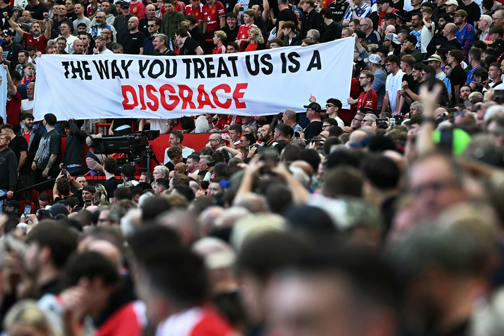 Manchester United fans hold up a banner in the stadium ahead of the English Premier League football match between Manchester United and Manchester City at Old Trafford in Manchester, north west England, on September 13, 2026.