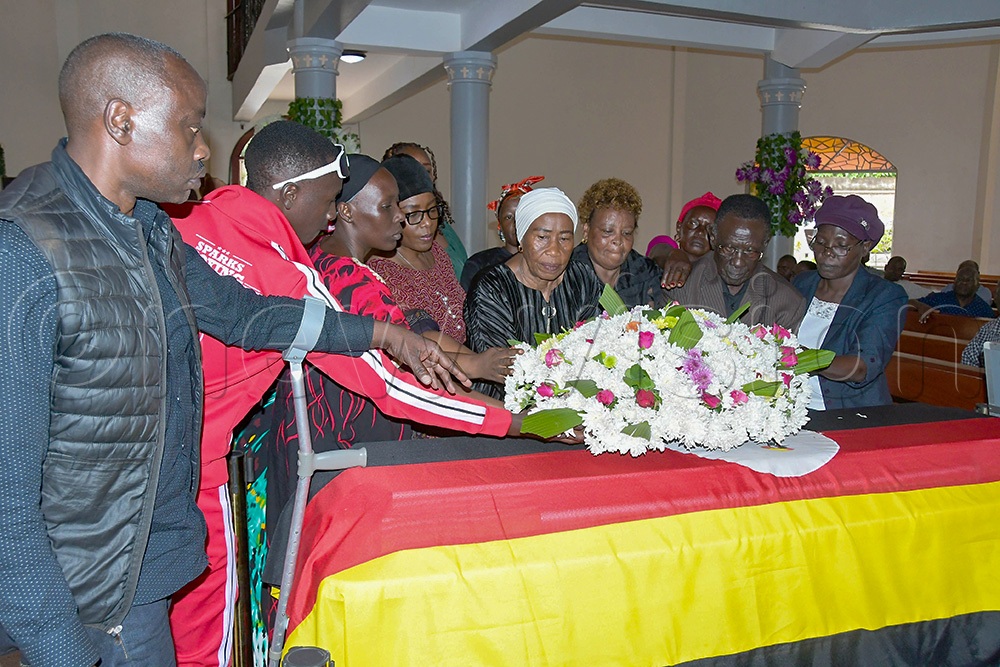 Family members of the late Polly Ouma laying a wreath on his casket. (Photo: Silvano Kibuuka)