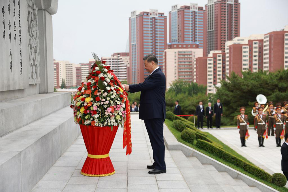 Xi Jinping, general secretary of the Communist Party of China Central Committee and Chinese president, straightens the ribbons on a flower basket while paying homage to the China-DPRK Friendship Tower with his wife Peng Liyuan, in the company of Kim Jong Un, general secretary of the Workers' Party of Korea and president of the State Affairs of the Democratic People's Republic of Korea (DPRK), and Kim's wife Ri Sol Ju, in Pyongyang, the DPRK, June 9, 2026. (Xinhua)