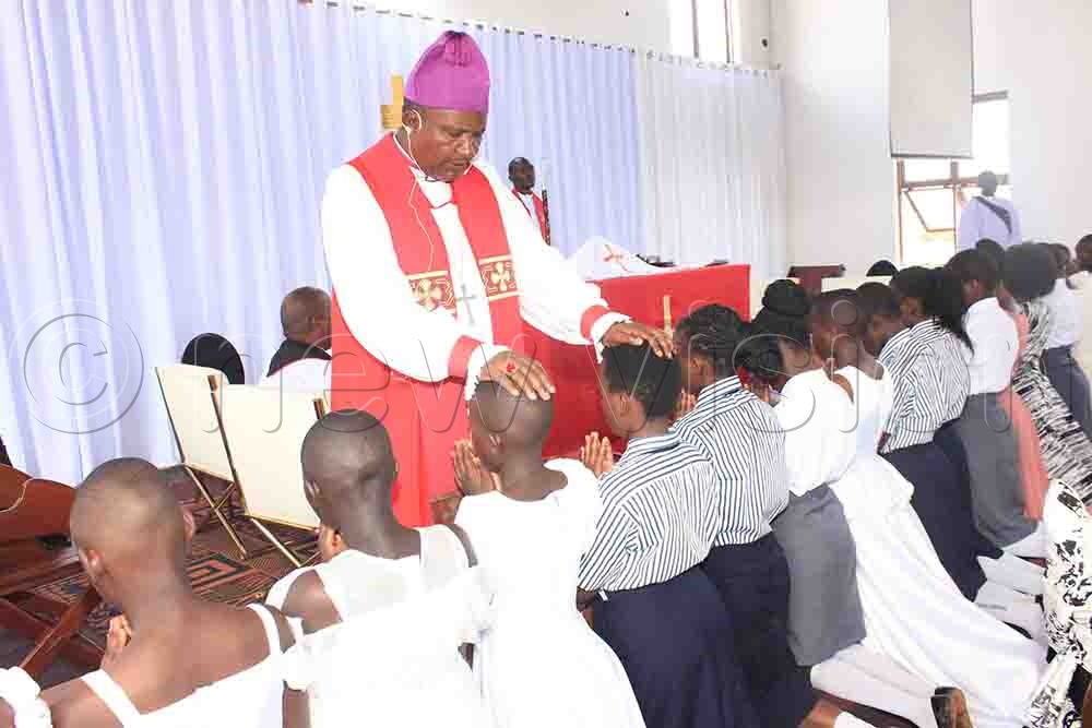 Bishop Kagodo confirms Christians during Palm Sunday service at St. Andrew Church in Misindye Parish, Seeta Archdeaconry. (Credit: Henry Nsubuga)