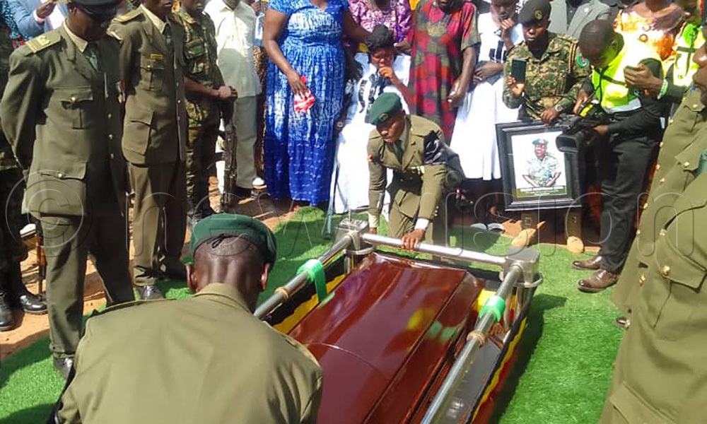 The casket with the remains of Major Armstrong Obua is lowered to the grave. (Photo by Hudson Apunyo)
