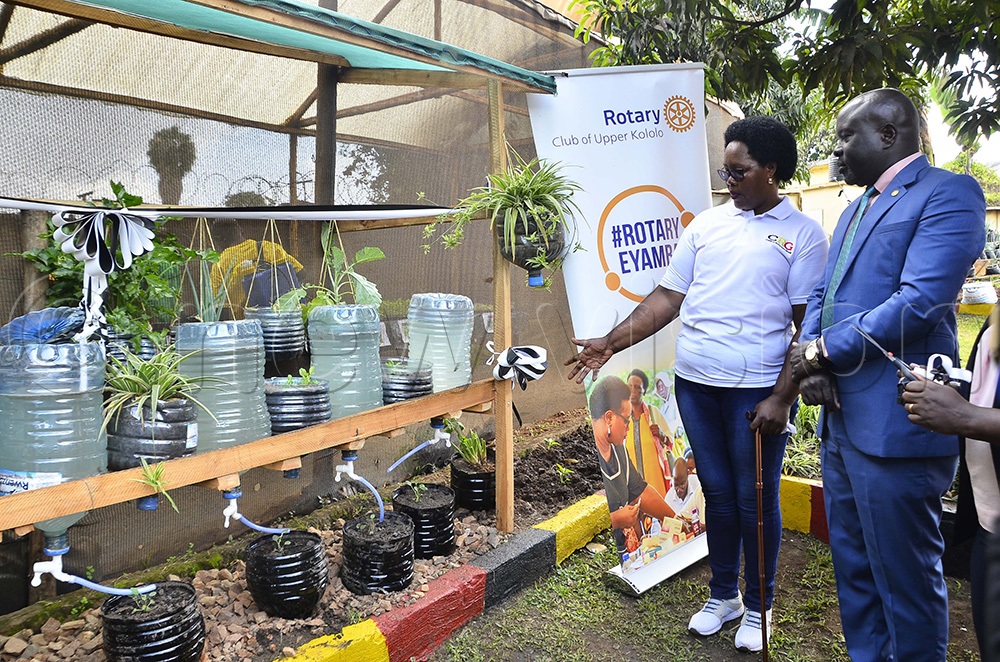 Mary Kyomugisha, Naguru Remand Home in charge, shows Gerald Obai, District Governor for District 9213, some of the projects done by children during the courtesy visit at Naguru Remand Home in Kampala on 14th August 2026. (Photo by Juliet Kasirye)