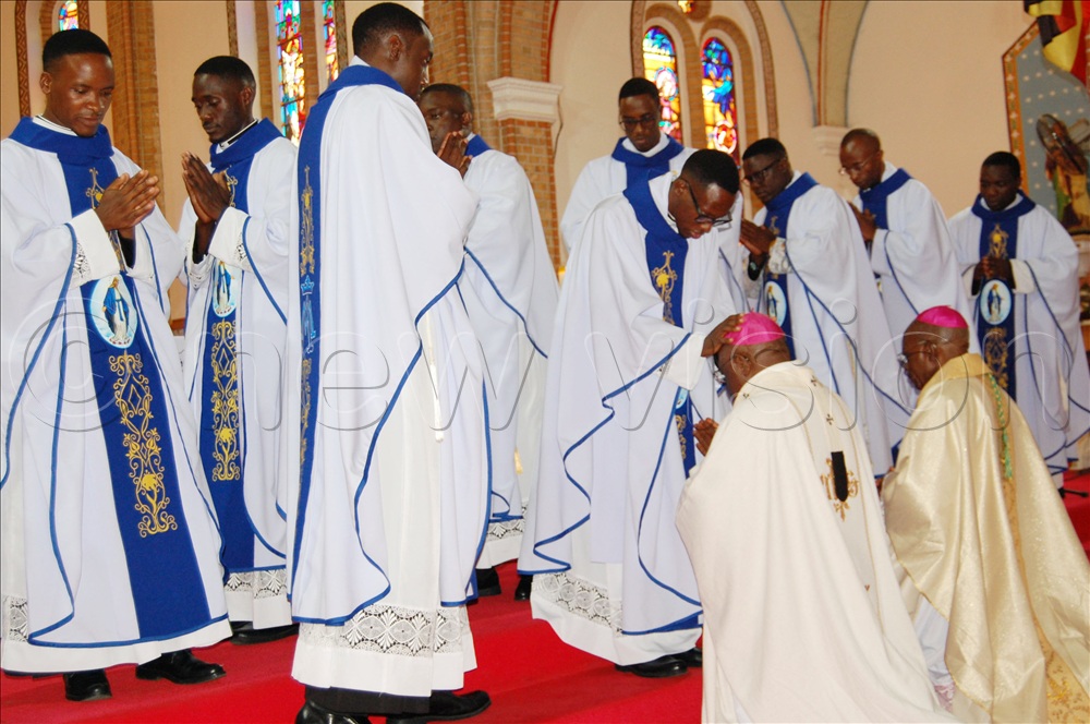 The newly-ordained priests imparting a sacerdotal blessing on the prelates; archbishop Paul Ssemogerere and archbishop Dr. Augustine Kasujja.