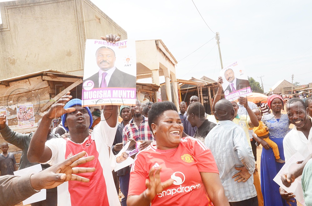 A resident holding a Muntu campaign poster during the campaign trail. (Credit: Isaac Nuwagaba)