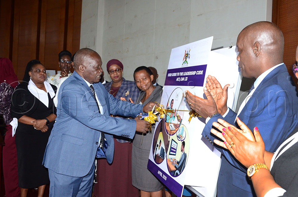 Hon. Wilson Muruli Mukasa, the Minister of Public Service, cutting a ribbon to symbolically launch the April 2026 Declaration period and the User Guide to the Leadership Code Act. Looking on is Dr. Roselyn Karugonjo Segawa (in black dress), the chairperson, Leadership Code Tribunal; Lady Justice Aisha Naluzze Batala (maroon veil), the Inspector General of Government (IGG); Lucy Nakyobe (grey coat), the Head of Public Service and Secretary to Cabinet; and Didas Bakunzi (extreme Right) of the Leadership Code Tribunal. This took place at the Office of the President in Kampala City on April 1, 2026. (Credit: Lawrence Mulondo)