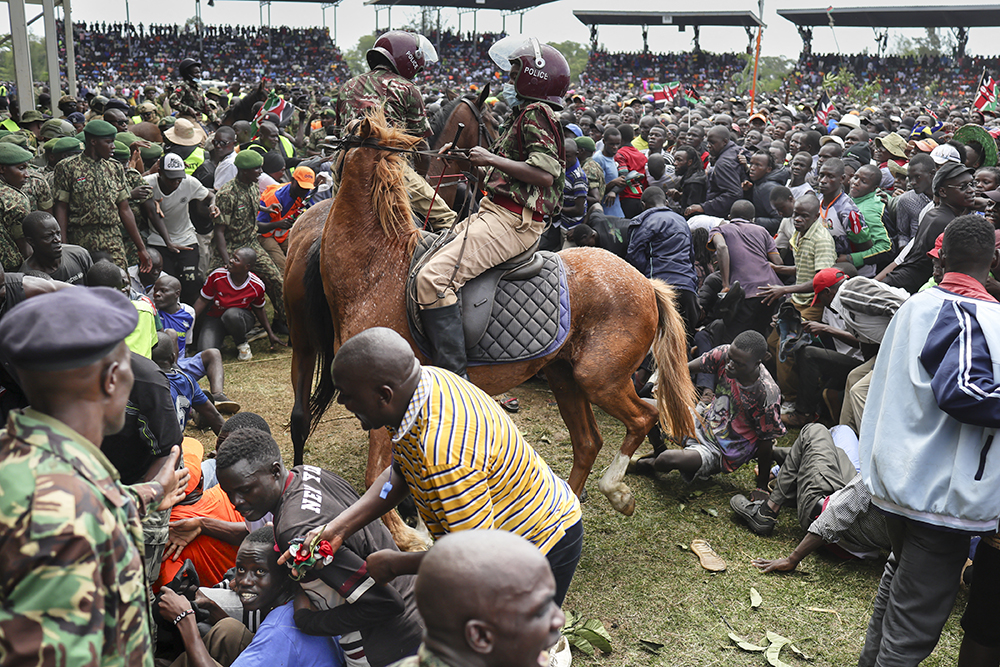Kenyan mounted police ride their horses into a crowd to quell a surge by mourners pushing forward during a public viewing of the body of Kenya’s opposition leader and former Prime Minister Raila Odinga at the Jomo Kenyatta Stadium in Kisumu on October 18, 2025. (AFP)