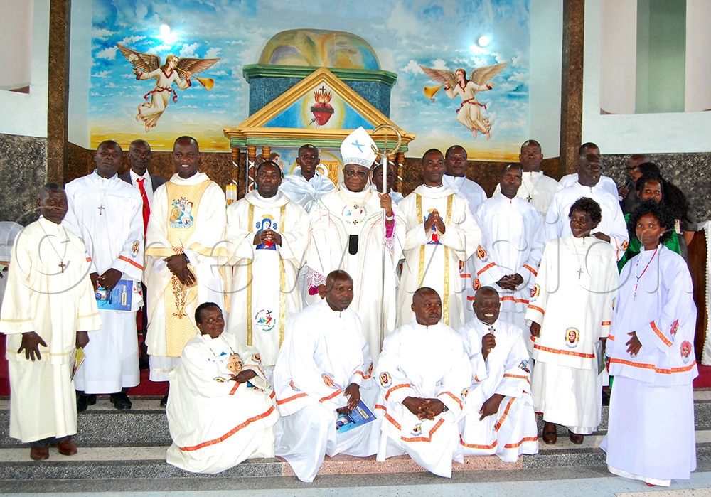 Archbishop Paul Ssemogerere (holding a crosier) shares a photo moment with the Catechists from the various sub-parishes of Bujuuko. (Photo by Mathias Mazinga)