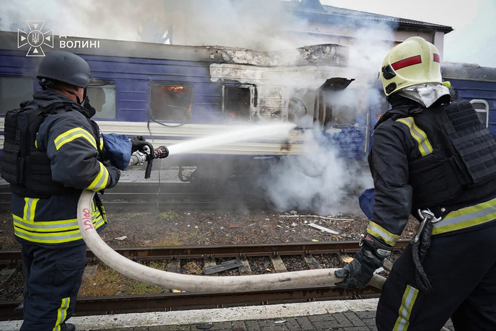 This handout picture taken and released by the Ukrainian State Emergency Service on September 13, 2026 shows firefighters spraying water at a train carriage damaged by a drone strike near the border with Poland. (Credit: AFP)