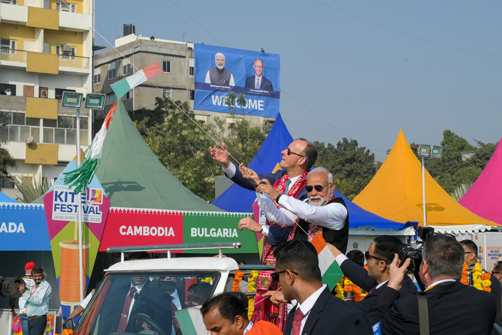 India's Prime Minister Narendra Modi (R) and German Chancellor Friedrich Merz fly a kite during the International Kite Festival in Ahmedabad on January 12, 2026. (Photo by Shammi MEHRA / AFP)