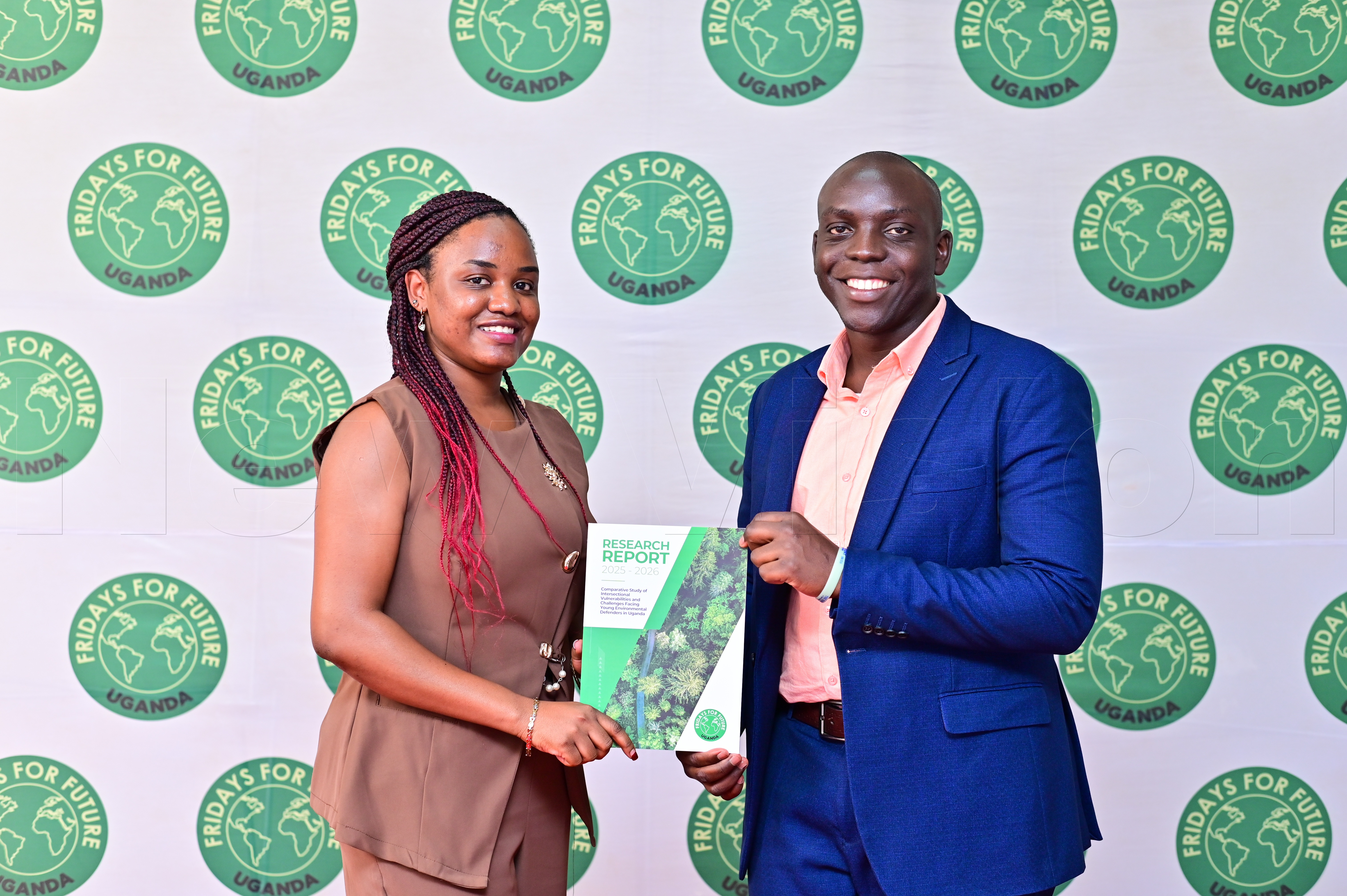 Resty Mubiiwa Ndholorwa of Fridays for Future Uganda and Derrick Sebaka of Habitat Defenders Africa (HDA) display the research report on young environmental defenders in Uganda.