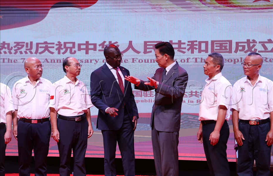  The Chinese Ambassador to Uganda H.E. Zhang Lizhong interacts with the Minister of State for Foreign Affairs in charge of Regional Affairs John Mulimba as the Chinese FAO team looks on during the Chinese National Day.