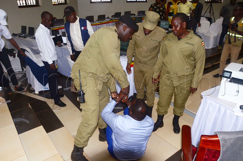 Police manhandling NUP's Najja Nasiifu who was protesting against declaring Kyeyune as the Wakiso district LC5-elect claiming that the victory was his and happened at the district headquaters. (Photo by Job Nantakiika)