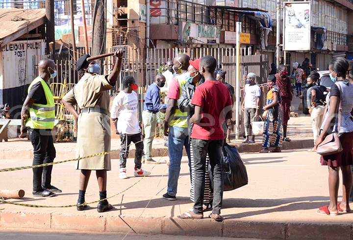 Omuserikale omukyala ng'atangira abantu okuyingira ekibuga