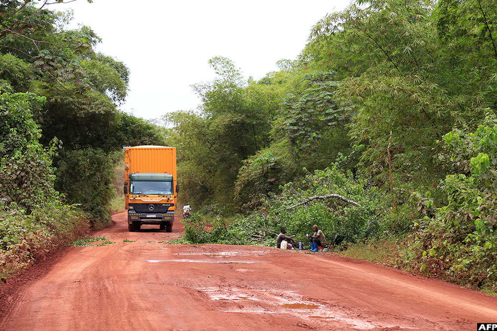 Small artisanal loggers sit resting on the RN4 in the heart of the Congo Basin forest near Kisangani in the northeast of DR Congo on September 25, 2019