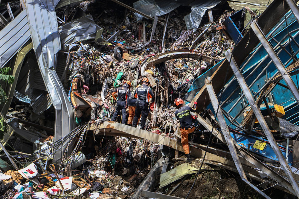 Members of the search and rescue team look for people after a landslide at the landfill in Barangay Binaliw, Cebu City on January 11, 2026. 