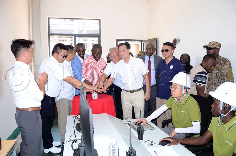 Balaam Barugahara (C) joins other investors to switch on the operator machines at YANGTZE Industry Limited in the Sino Mbale Industrial park. This was during the official commissioning of the industry in Mbale city on Thursday. (Credit: Lawrence Mulondo)