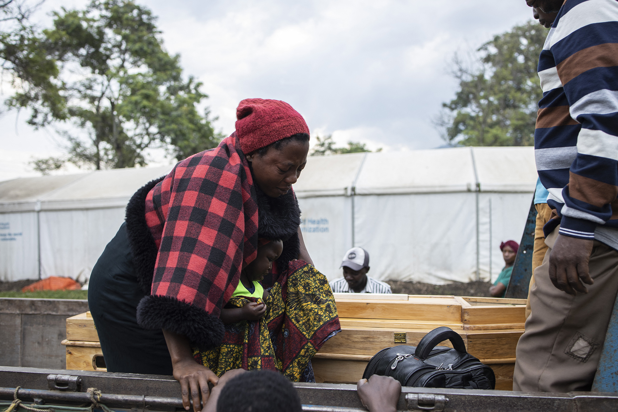 A relative of a victim of the Mpondwe Lhubiriha Secondary School mourns as she leans towards a casket outside the Bwera General Hospital Mortuary, Kasese, on June 18, 2023. AFP Photos