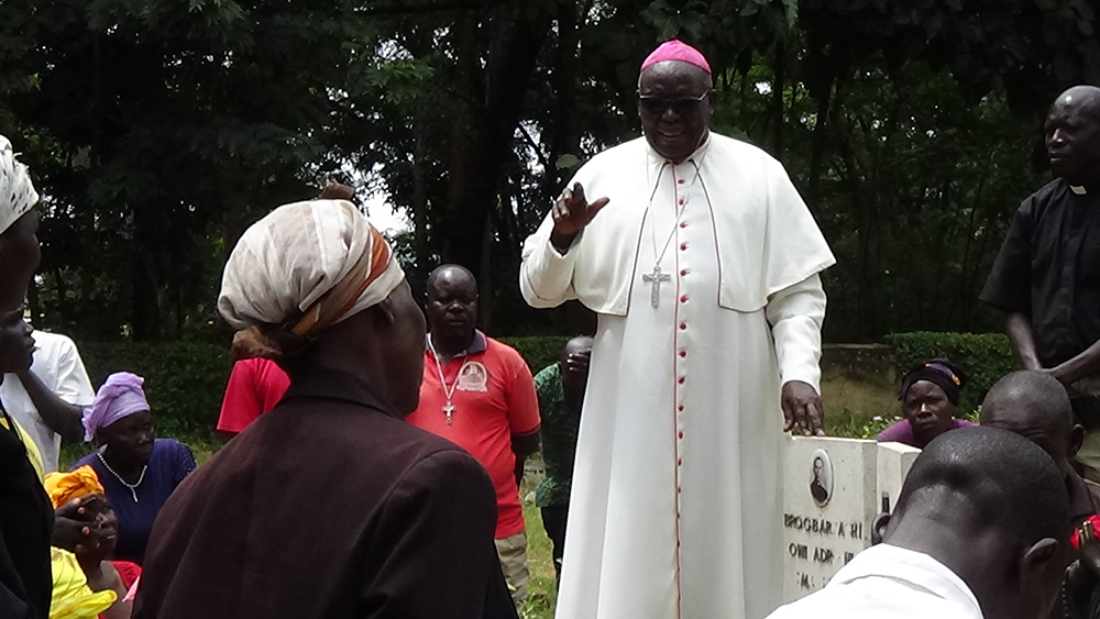 Archbishop O’dama prays at the grave of Fr Barnado Sartori. (Photo by Denis Oringi)