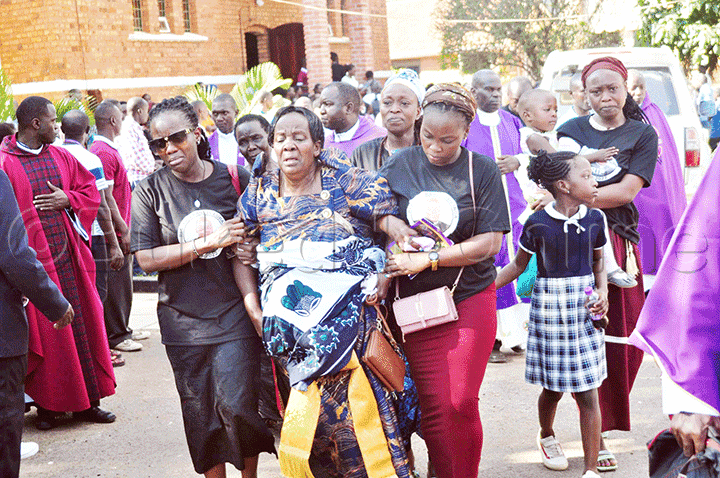 Maama w'omugenzi ng'abamuwaniridde wakati mu maziga.