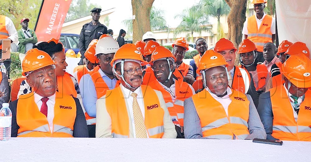 The Vice Chancellor of Makerere University, Prof. Barnabas Nawangwe (second left) and other university staff from the college of business at the institution listening to speeches.