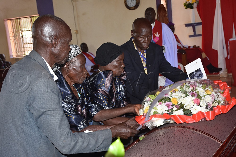  Relatives laying a wreath on Mzee Nathan Okori Adiyo's casket at Christ Church in Gulu City. (Photo by Dennis Ojwee)