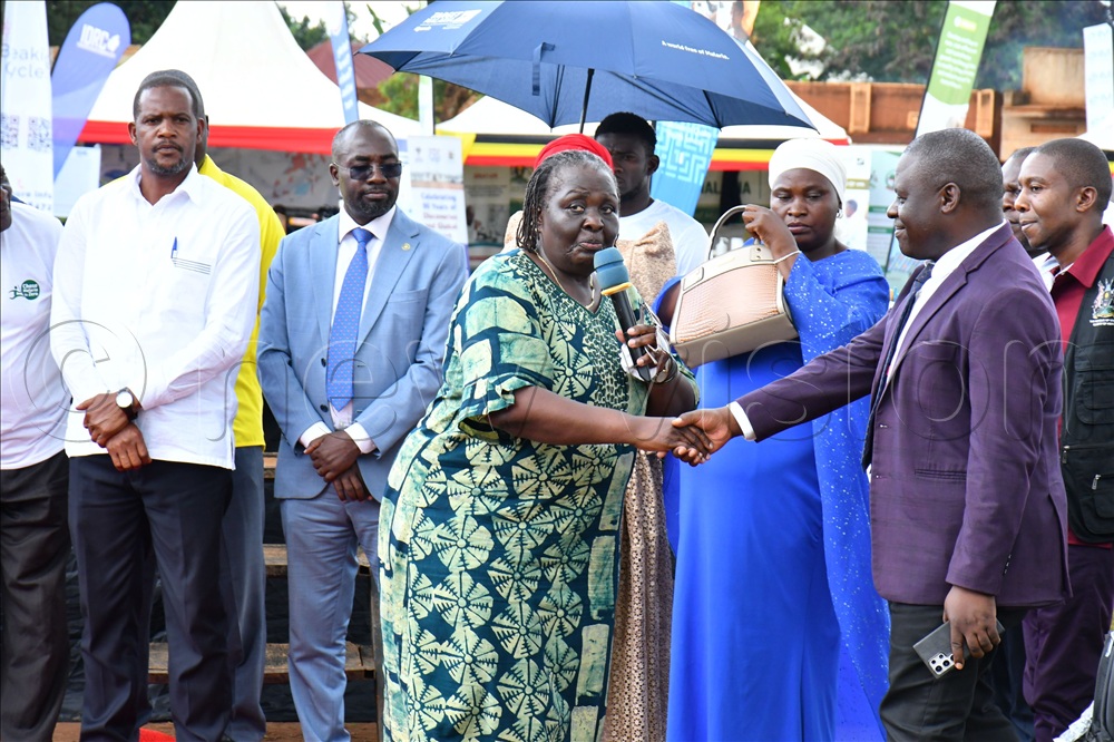 Former Vice President Dr. Specioza Wandira Kazibwe (middle) who serves as the Busoga Health Forum Malaria Champion and Presidential Advisor on Population and Health introducing Prof. Peter Waiswa (right), the chairman Busoga Health Forum, before guests, while at celebrations to mark World Malaria Day at Bulamaji sub county headquarter ground in Iganga district.  