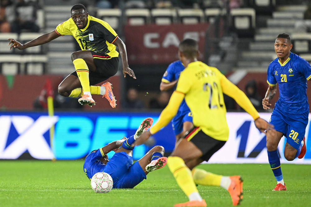 Uganda's midfielder #12 Baba Alhassan and Tanzania's midfielder #20 Novatus Miroshi vie during the Africa Cup of Nations (CAN) Group C football match between Uganda and Tanzania at Al Medina Stadium in Rabat on December 27, 2025. (Photo by SEBASTIEN BOZON / AFP)