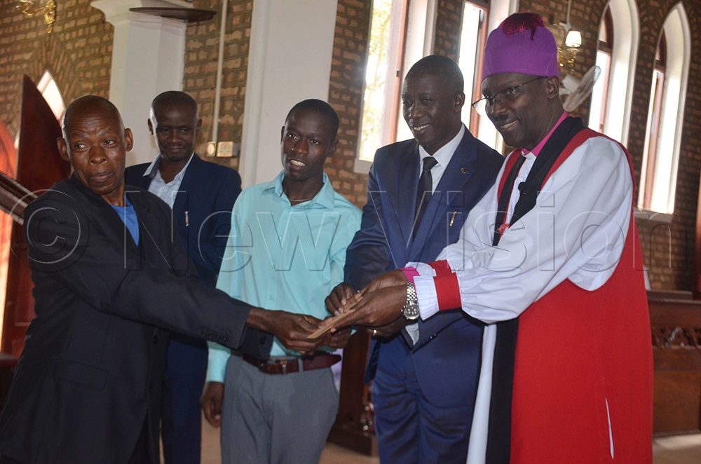 The bishop of Ankole diocese, Rt. Rev. Fred Sheldon Mwesigwa, handing over a gift to one of Mbarara High School's excellent performers of UACE exams 2025. This was shortly after a dedication service held at St James Cathedral-Ruharo in Mbarara City on Monday. (Credit: Abdulkarim Ssengendo)