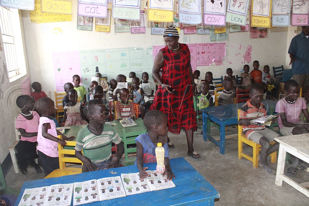 Teacher Zema Ilukol supervises a Primary One class as pupils engage with Toto Magazine. (Credit: Ritah Mukasa)