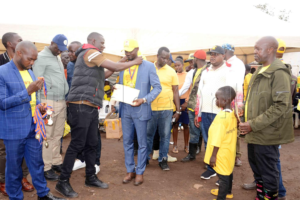 Brian Olala Okidi ng'ayambaza Juma Tinyefuza omudaali