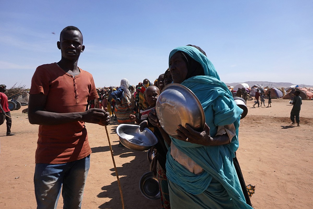 A handout picture released by the International Committee of the Red Cross (ICRC) on November 18, 2025 shows displaced civilians who have fled violence in El-Fasher gathering by makeshift camps in the city of Tawila. The horrific bloodshed in the Sudanese city of El-Fasher is a "stain" on the world, the UN said, urging the international community to act following warnings of crimes against humanity and genocide. Since breaking out in April 2023, the war between Sudan's army and the paramilitary Rapid Support Forces has killed tens of thousands of people, displaced nearly 12 million more and triggered one of the world's worst humanitarian crises. The violence has escalated dramatically in recent weeks, with the RSF seizing control of the key town of El-Fasher in Sudan's western Darfur region after an 18-month siege and reports of atrocities multiplying.