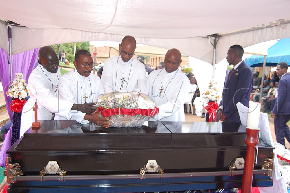 Bro. Muyunga's classmates, led by Bro. Augustine Mugabo (third-left) laying a wreath on the casket bearing his remains. (Photo by Mathias Mazinga)