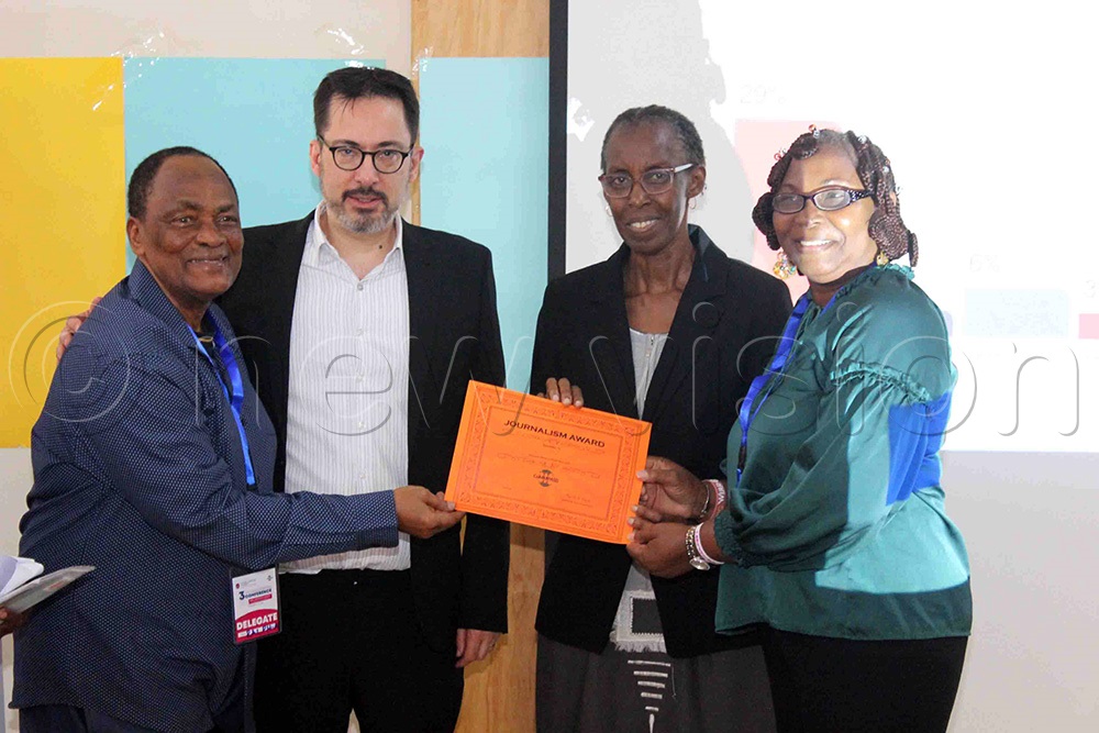 Dr. Michael Leroy (second left), the academic manager COMMPASS-Research, Dortmund University and Prof. Monica Chibita (second right) of UCU handing over the certificate of the winning Nigerian journalist Henry Nwachukwu to Prof. Ralph Afolabi Akinfeleye (left) of the University of Lagos, Nigeria. (Photo by Henry Nsubuga)