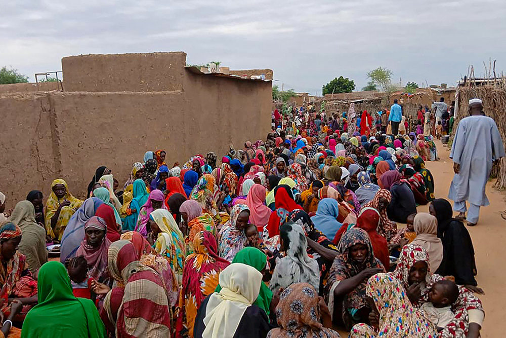 Sudanese residents gather to receive free meals in Al Fasher, a city besieged by Sudan's paramilitary Rapid Support Forces (RSF) for more than a year, in Darfur region, on August 11, 2025. (Photo by AFP)