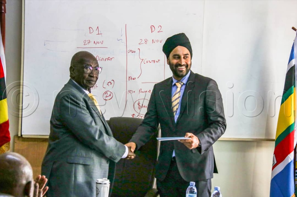 Rajbir Singh Rai receives instruments of power from Trade minister Francis Mwebesa as the new chairperson of the sugar council. 