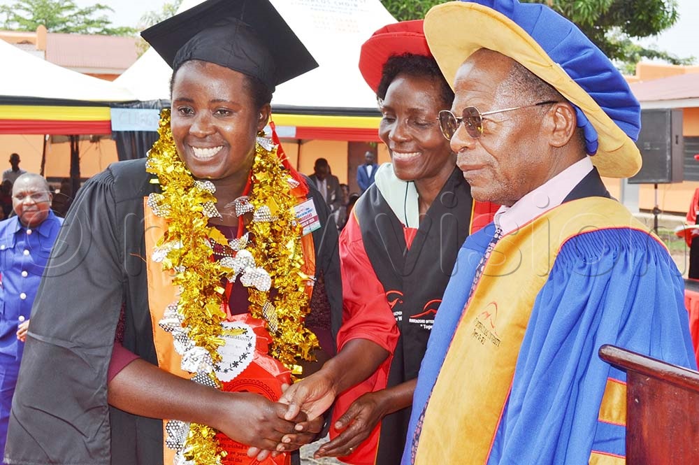 Professor Nalwoga and minister Muyingo congratulate Phellestus Masika, the university's first Guild President, who graduated with a diploma in primary education. (Credit: John Thawite)