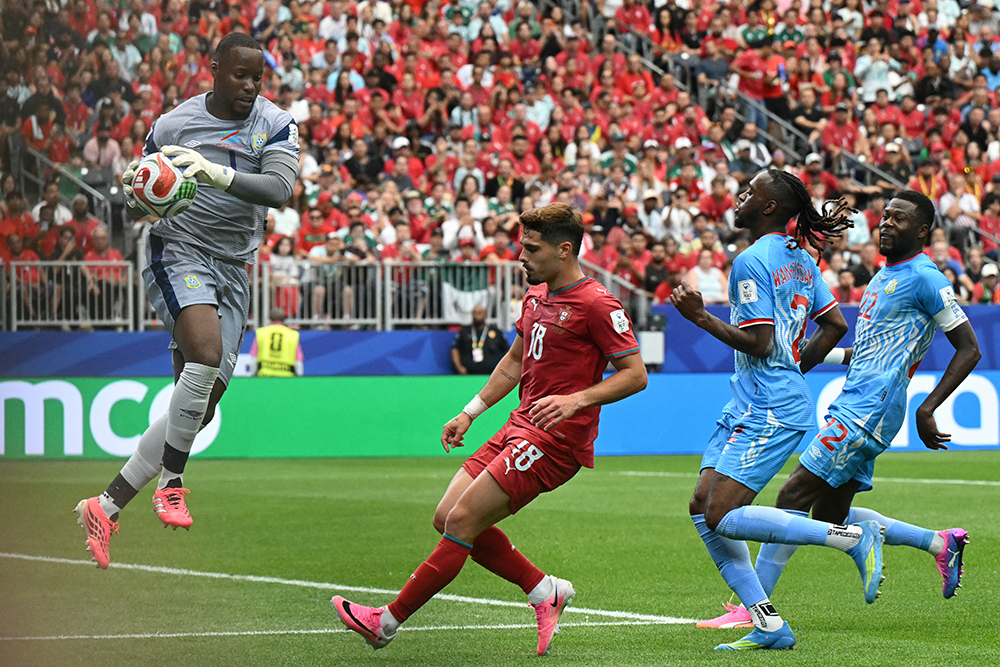 Congo DR's goalkeeper #01 Lionel Mpasi (L) catches the ball in fornt of Portugal's forward #18 Pedro Neto (C) during the 2026 World Cup Group K football match between Portugal and the Democratic Republic of Congo at the Houston Stadium in Houston on June 17, 2026.  