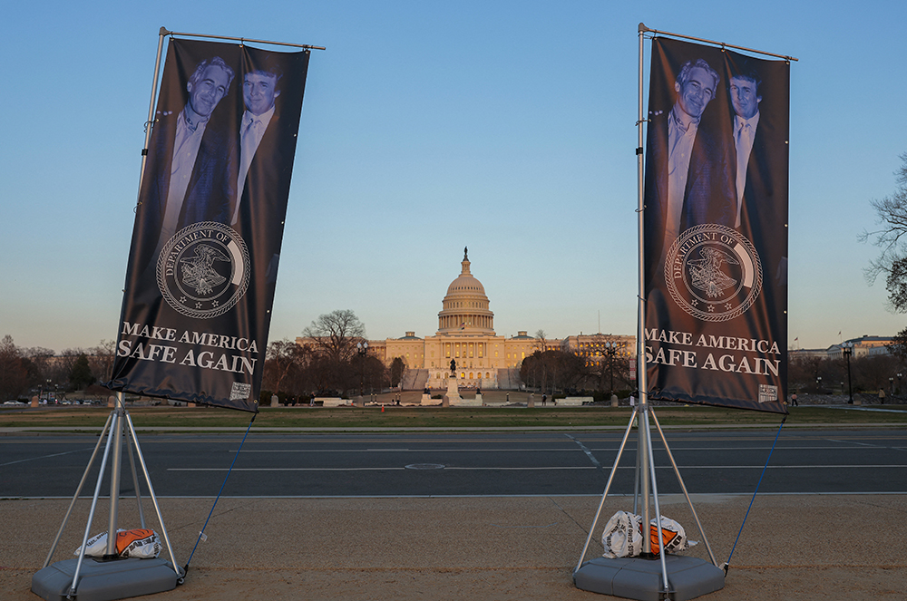 Banners hang near a "Titanic"-themed satirical statue of U.S. President Donald Trump and late convicted sex offender Jeffrey Epstein on the National Mall on March 10, 2026 in Washington, DC. The statue was placed by anonymous artists who also erected one of Trump and Epstein holding hands titled "Best Friends Forever" back in September.