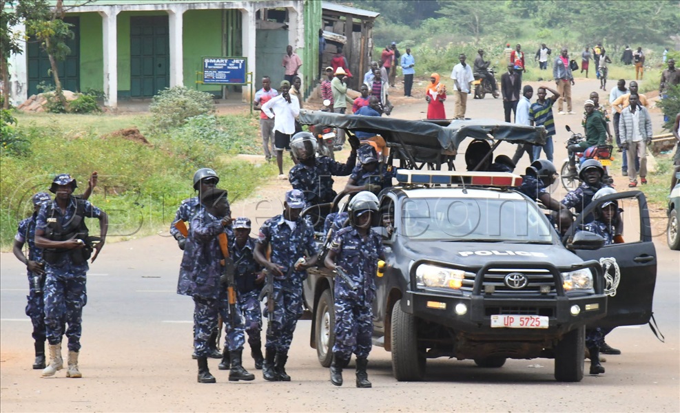 Abaserikale Ba Poliisi Abagugumbudde Abantu Mu Luguudo Wakati Ne Ttiyagaasi Okusobozesa Mmotoka Okuyita.