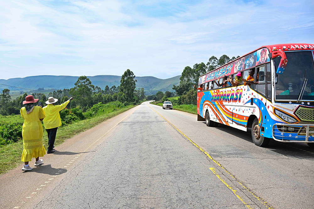 President Museveni waving to bus passengers as he takes a walk with first daughter Patience Rwabwogo. (Courtesy/PPU)
