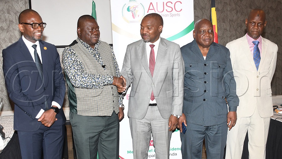 Outgoing advisory board chairman Patrick Ogwel (2nd left) shakes hands with incoming chairman Júlio Ambali Mendes (center) as Chipande (left), Zenon Kasongo Kabamba and Abbas Bah (right) look on after the meeting. Photo by Michael Nsubuga