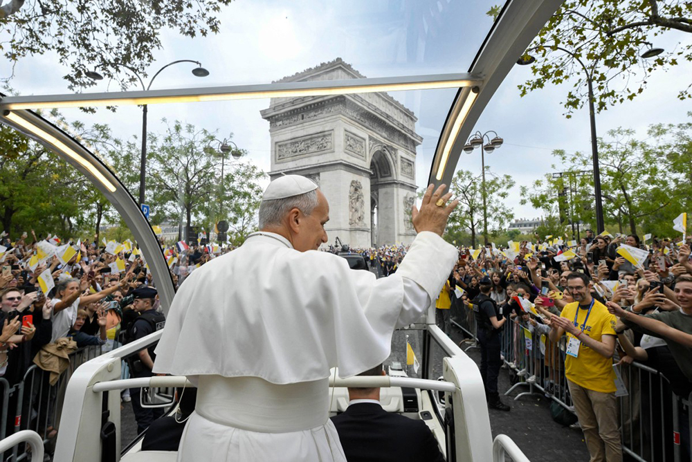 This handout photo taken on September 26, 2026 and released by the Vatican press office, Vatican Media, shows Pope Leo XIV waving to the crowd from the Papamobile (popemobile) in front of the Arc de Triomphe on his way to the Place de la Concorde, central Paris, on September 26, 2026 to celebrate a solemn outdoor mass, on the second day of his visit to France. Pope Leo XIV celebrates an open-air mass for hundreds of thousands of believers on the Champs Elysees in Paris, after saying it was possible to "live together in dignity and peace".  (AFP)