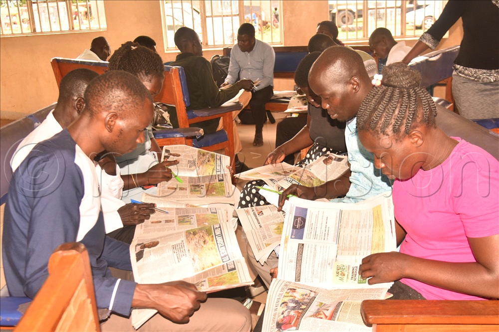 Teachers in Amuru going through the new vision newspaper to make learning materials