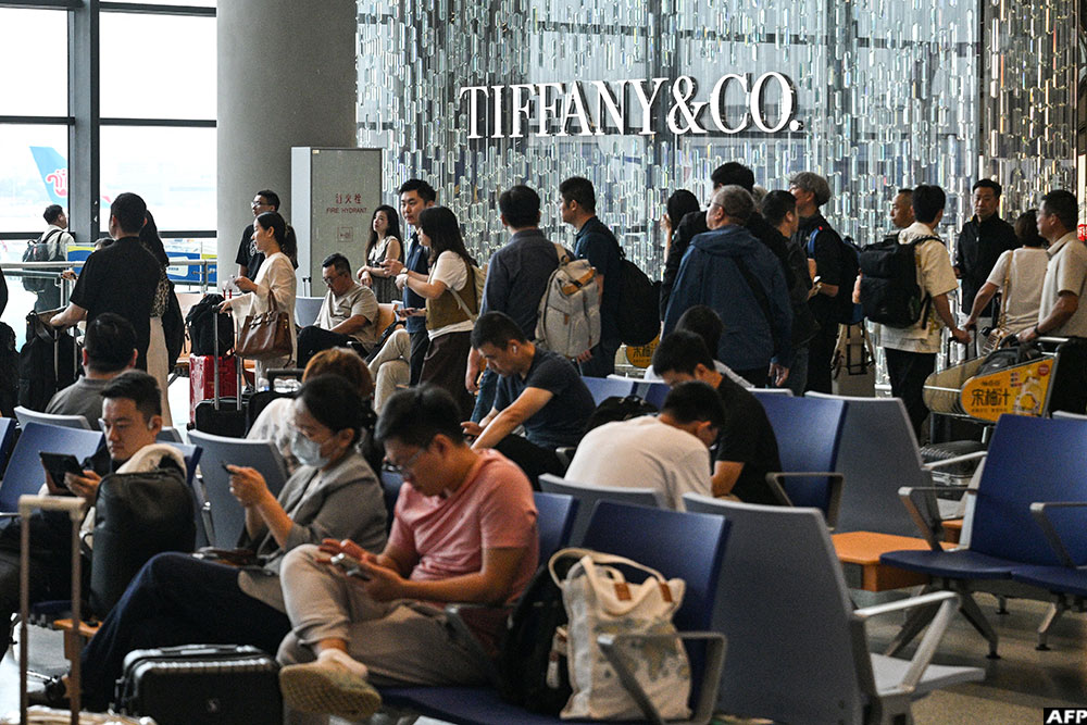 Passengers waiting for their flight are seen next to a Tiffany & Co. shop at Shanghai Hongqiao International Airport in Shanghai.