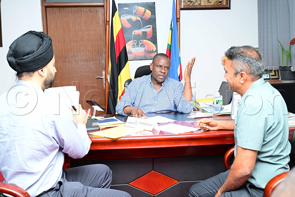 State minister for youth and children affairs Balaam Barugahara (middle) brokered the MOU between Kinyara and Victoria in his office. (Credit: Eddie Ssejjoba)