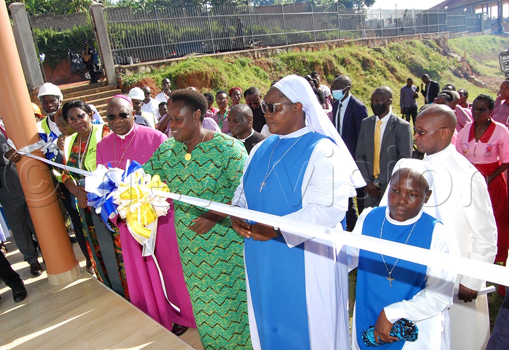Archbishop Paul Ssemogerere (wearing a purple cassock) and other Christians look on as Vice-Pesident Jessica Alupo cuts the tape commission the Book Shop Premises of the Catholic nuns of Bukalango. (Photo by Mathias Mazinga)